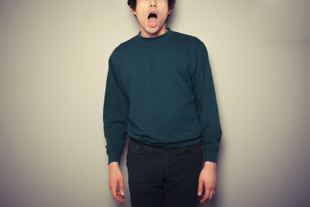 A young man is surprised and has his mouth openの写真素材