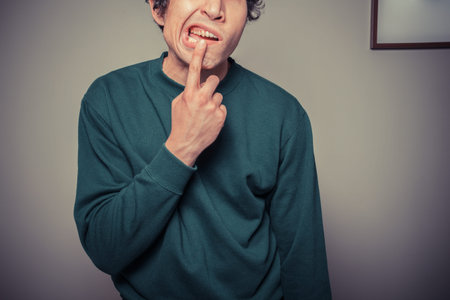 A young man is gesturing and pulling silly faces