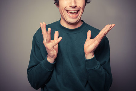 A young man is gesturing and pulling silly facesの写真素材