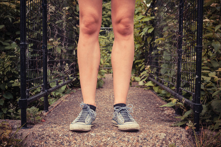 Close up on the legs of a young woman as she is standing outside in nature on a spring dayの写真素材