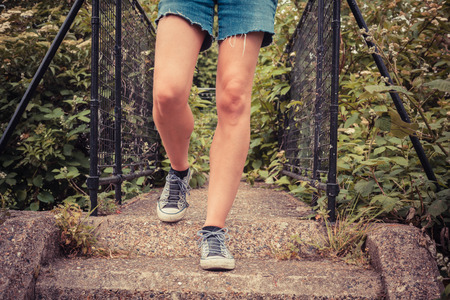 Close up on the legs of a young woman as she is standing outside in nature on a spring dayの写真素材