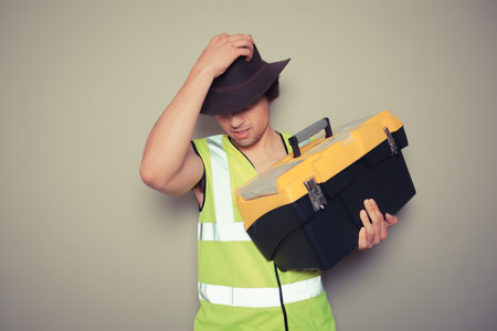 A cowboy builder with a big tool box is pulling silly faces and gesturingの写真素材