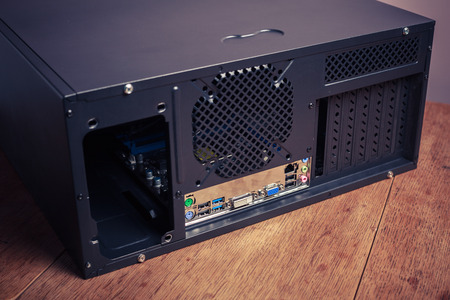 A computer case is lying on a wooden tableの写真素材