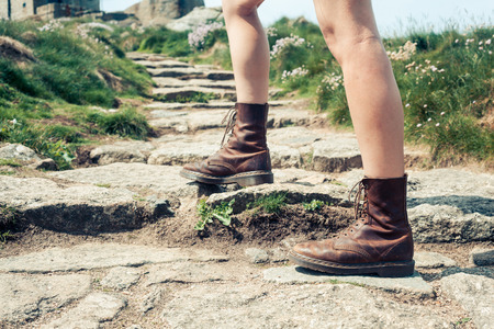 Closeup on a young woman's feet as she is hiking up a rocky trailの写真素材