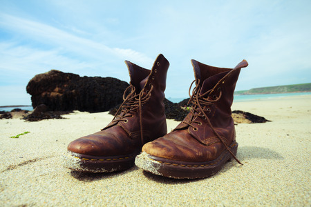 A pair of hiking boots on the beach in summerの写真素材