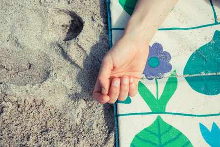 A young woman is relaxing and sunbathing on the beachの写真素材