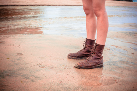 The legs of a young woman standing on the beachの写真素材