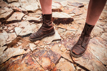 The feet of a young woman as she is standing on a rocky surfaceの写真素材