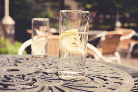 Two glasses with lemon on a table in a gardenの写真素材