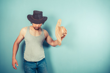 A young man is trying on two different hatsの写真素材