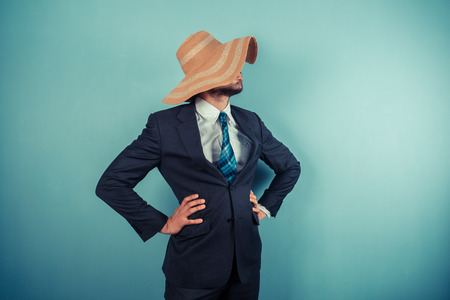 A young businessman is wearing a large beach hatの写真素材