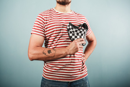 A young man is wearing a striped shirt and a checkered capの写真素材
