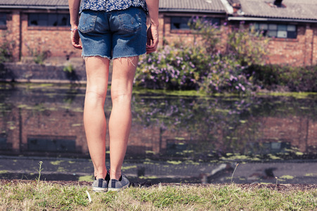 A young woman is standing by a canalの写真素材