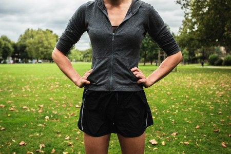 A young woman wearing shorts is standing in the parkの写真素材