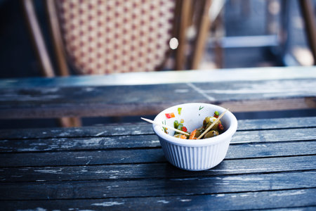 A small bowl of olives on a table outside