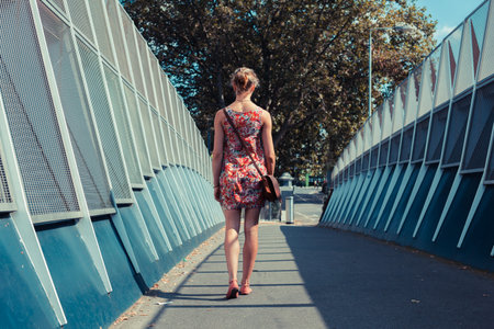 A young woman is walking in the street on a summer's day