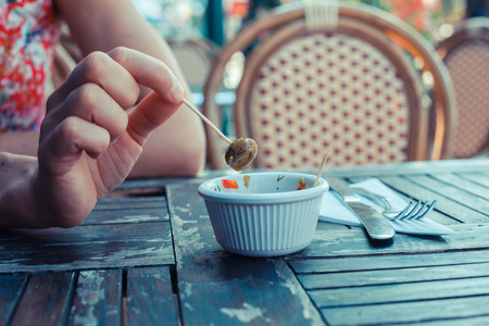 Close up on a woman's hand picking olives from a bowl with a toothpick outsideの写真素材