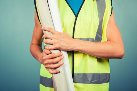 A female engineer is holding some building plansの写真素材