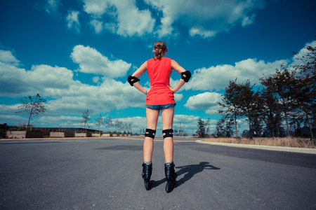 A young woman is skating on rollerblades in an urban settingの写真素材