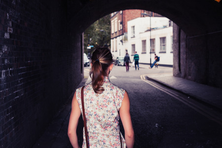 A young woman is standing in a tunnelの写真素材