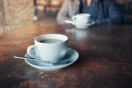 A cup of black coffee on a rustic tableの写真素材