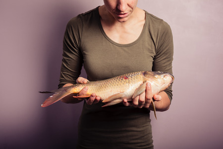 A young woman is holding and examining a carpの写真素材