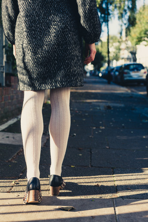 The legs of a young woman as she is walking in the streetの写真素材