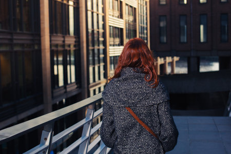 A young woman is walking in the street at duskの写真素材