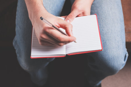 A man is taking notes in a notebook