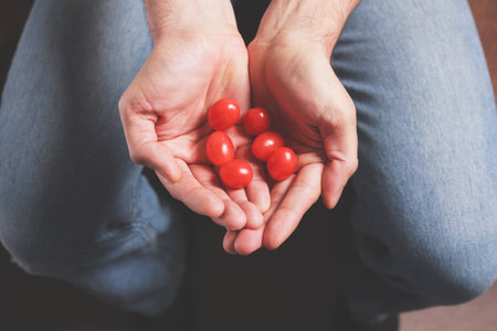 A man is holding a handful of tomatoesの写真素材