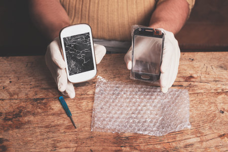 A technician is fixing and replacing the broken screen on a smart phone