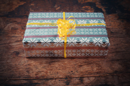 A gift wrapped present on a wooden table