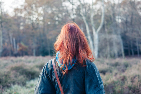A young woman is standing in the forest in autumn