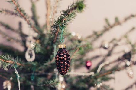 A decorative cone hangin from a christmas tree