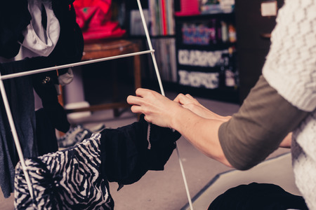 A young woman is at home sorting through her laundryの写真素材