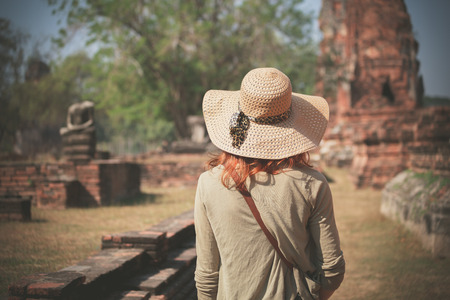 A young woman is exploring the ancient ruins of a buddhist temple cityの写真素材