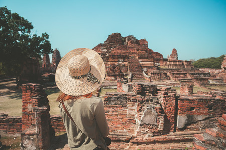 A young woman is exploring the ancient ruins of a buddhist temple cityの写真素材