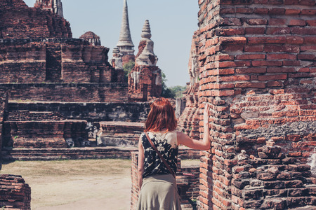 A young woman is exploring the ancient ruins of a buddhist temple cityの写真素材