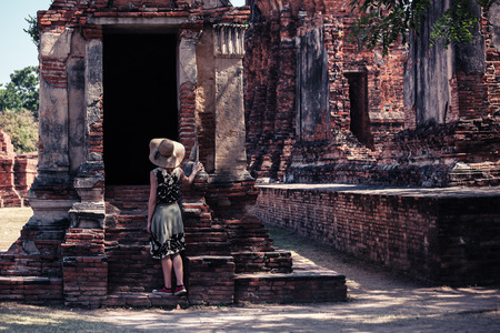 A young woman is exploring the ancient ruins of a buddhist temple cityの写真素材