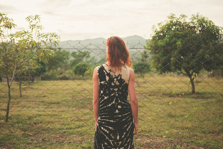 A young woman is walking around a farm in a tropical Asian countryの写真素材