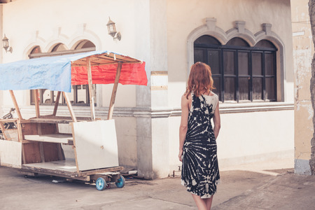 A young caucasian woman is walking around a small town in a developing countryの写真素材