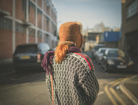 A young woman is walking on the quiet streets of a city in the winterの写真素材