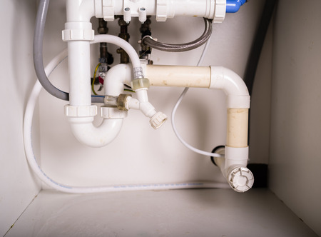 Piepes and plumbing under a kitchen sinkの写真素材