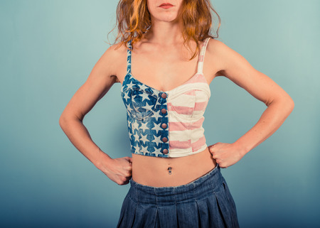 A happy young woman is wearing a stars and stripes topの写真素材