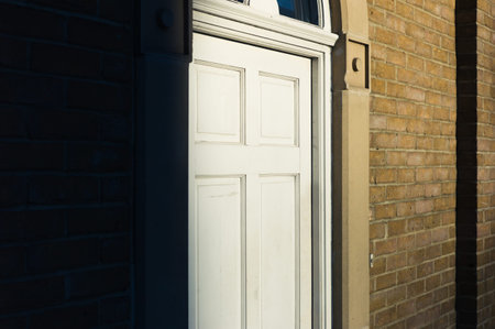 A white door of a house bathed in the afternoon sun