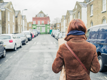 A young woman is walking in the street in winterの写真素材