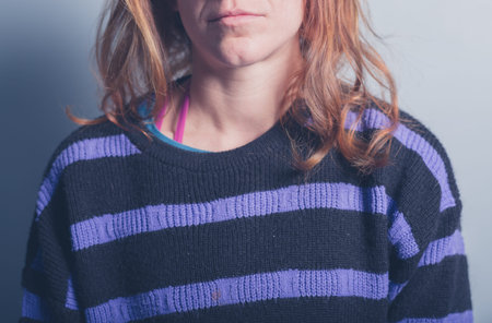 A young woman is wearing a stripey purple and black jumperの写真素材