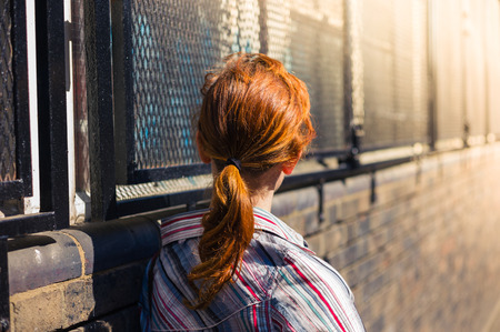 A young redhead woman is relaxing in the street on a sunny and warm spring dayの写真素材