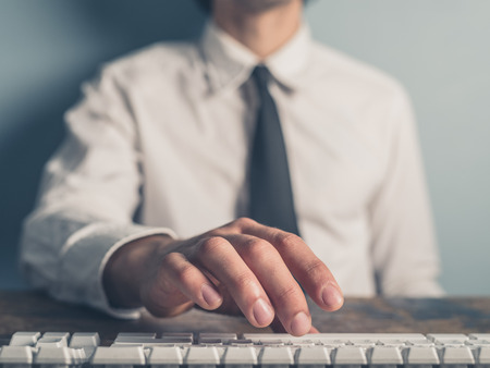 A young businessman is typing on a keyboardの写真素材