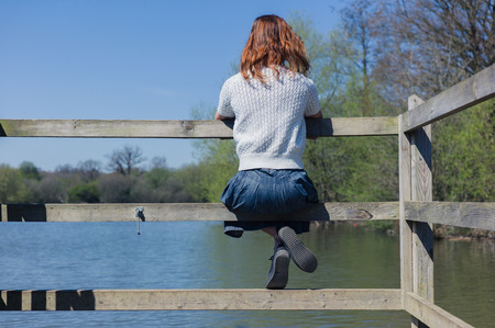 A young woman is relaxing by a lake in a forestの写真素材